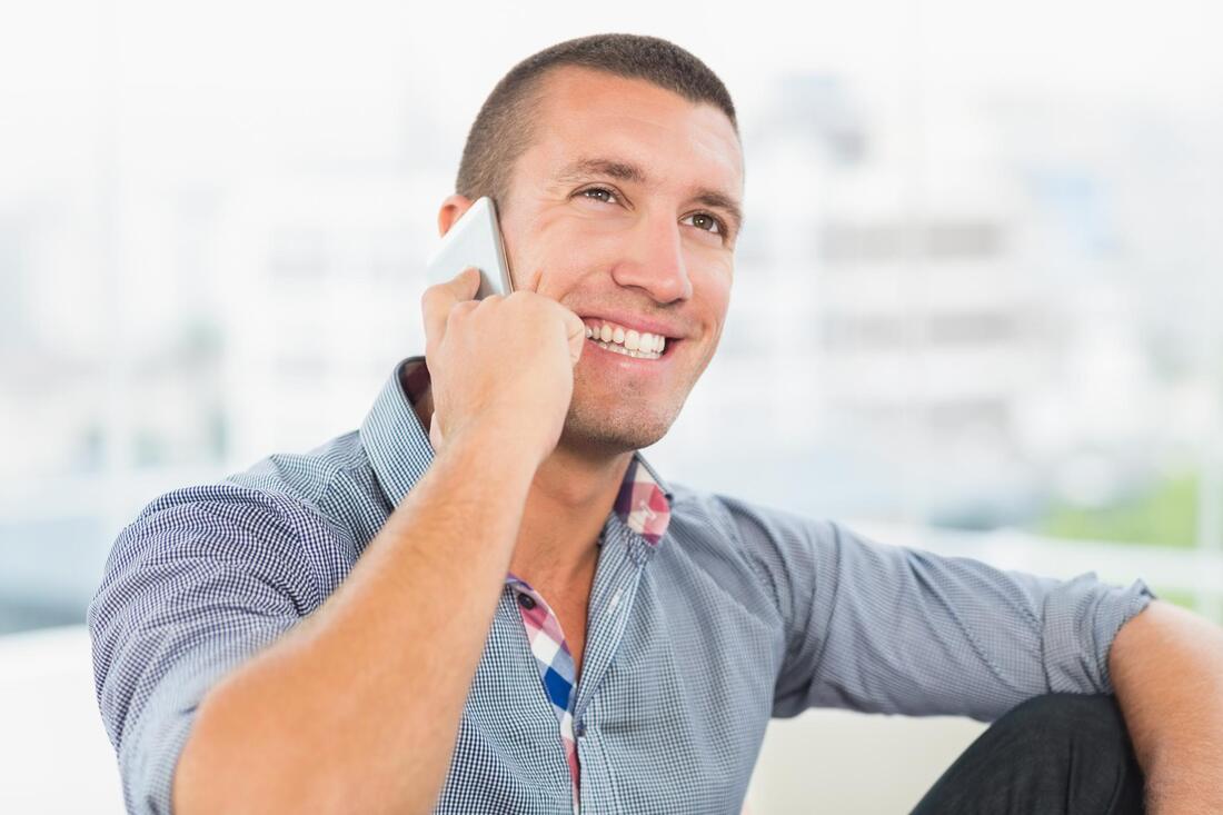 a man happily taking call