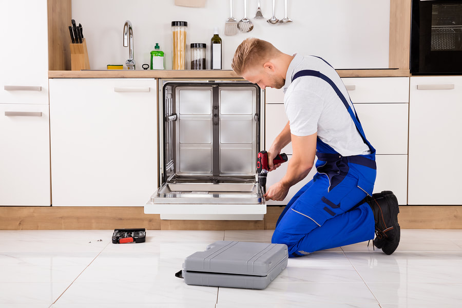 man drilling the dishwasher